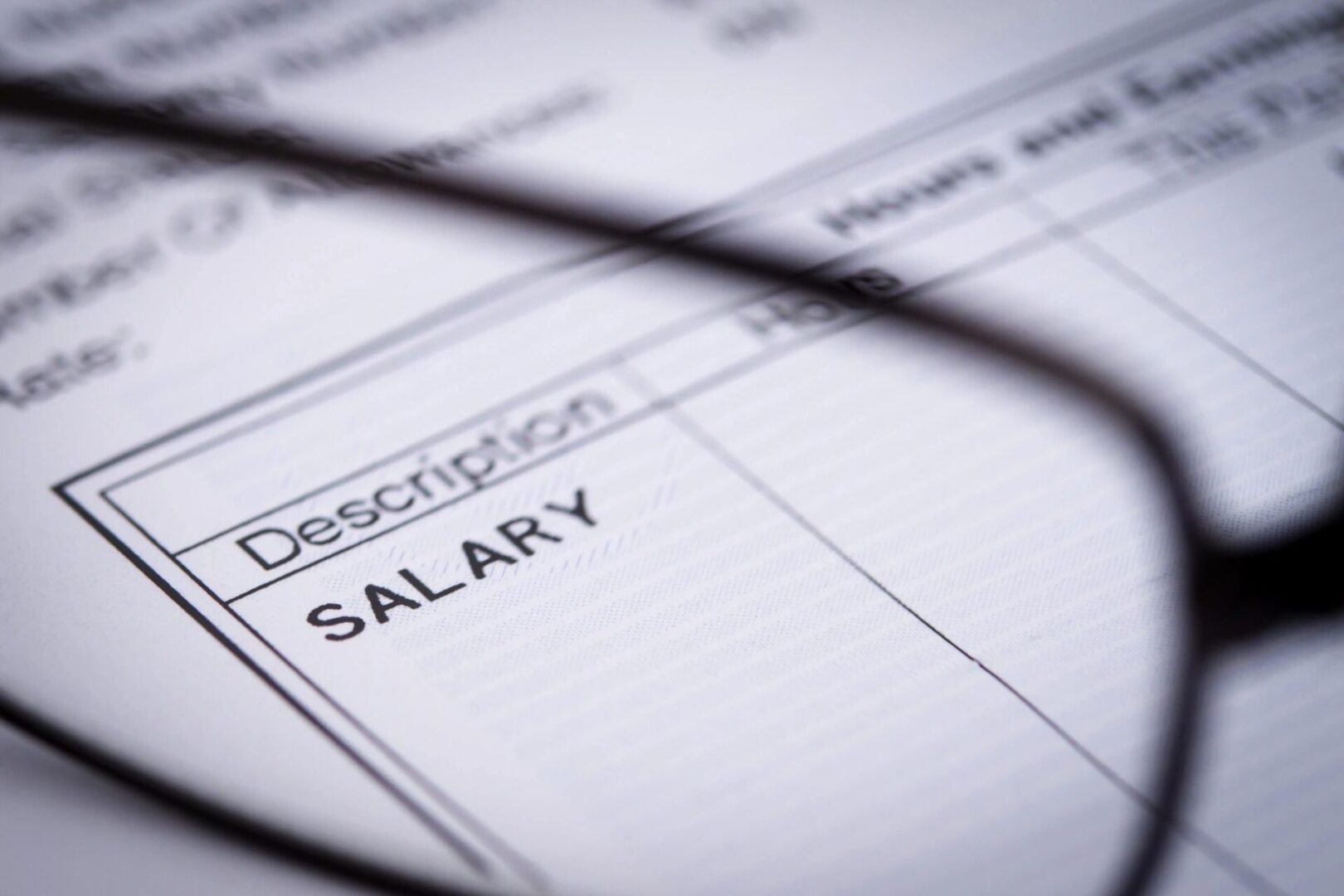A close up of the salary sheet with glasses